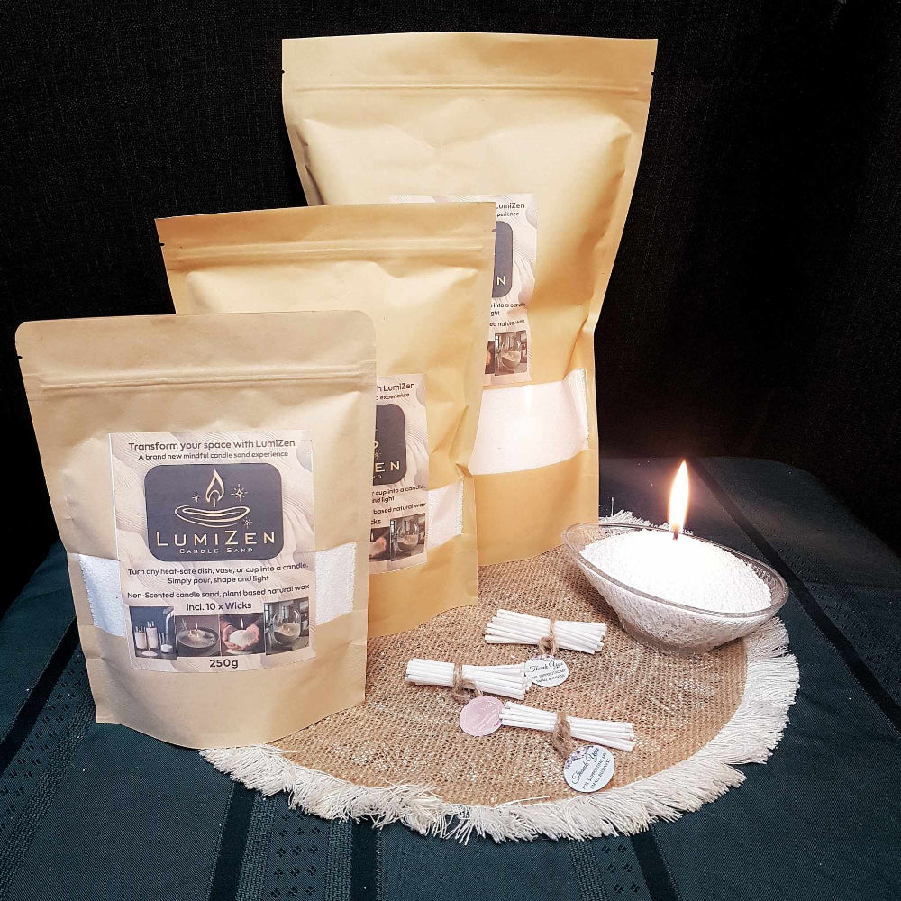 Lumizen candle sand white 3 sizes displayed with burning candle 